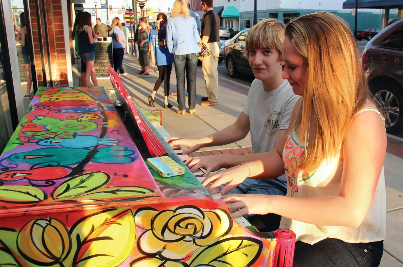 Kids play on a painted piano in the street at the First Friday Art Walk in Elizabeth City, North Carolina