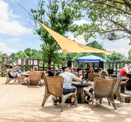 Patrons enjoy beverages and food on an outdoor patio at Double Barley Brewery in Johnston County, North Carolina