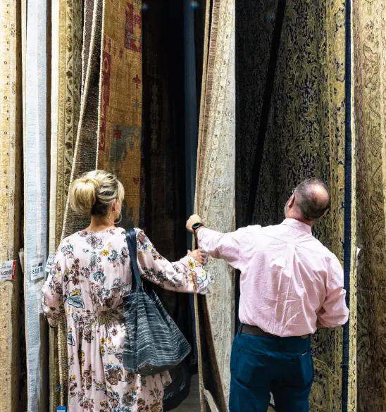 A couple looks at floor rugs on display at FurniturelLand South in High Point, North Carolina