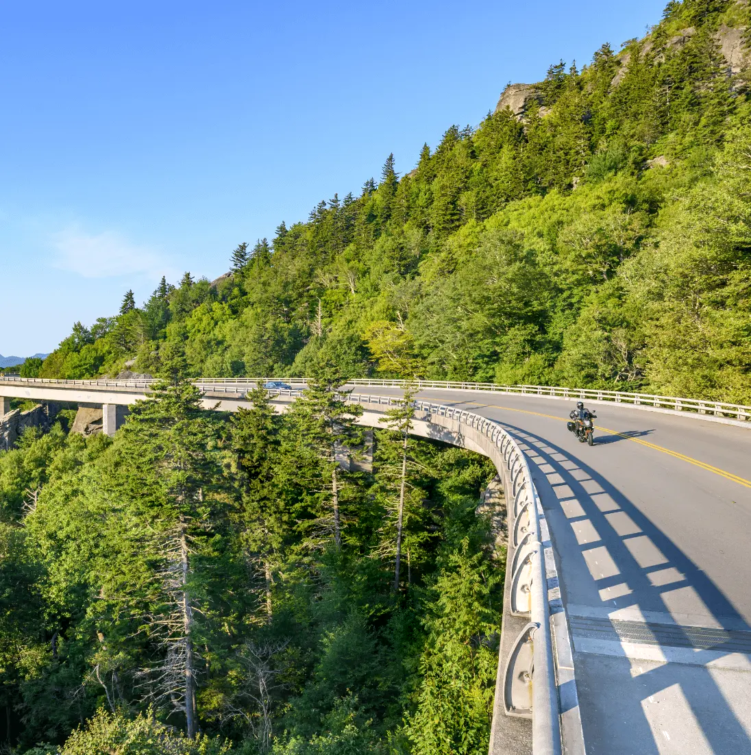 A motorcyclist rides through a winding stretch of the Linn Cove Viaduct on the Blue Ridge Parkway in North Carolina
